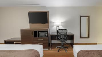 A hotel room with two beds, a desk with a chair, a flat-screen TV, a microwave, a lamp, and a mirror.