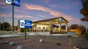 A Best Western hotel with a covered outdoor seating area and a clear sky.