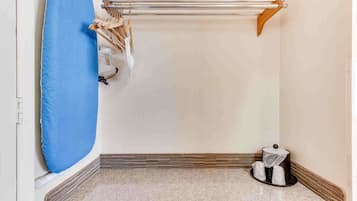 Escritorio, cortinas blackout y tabla de planchar con plancha