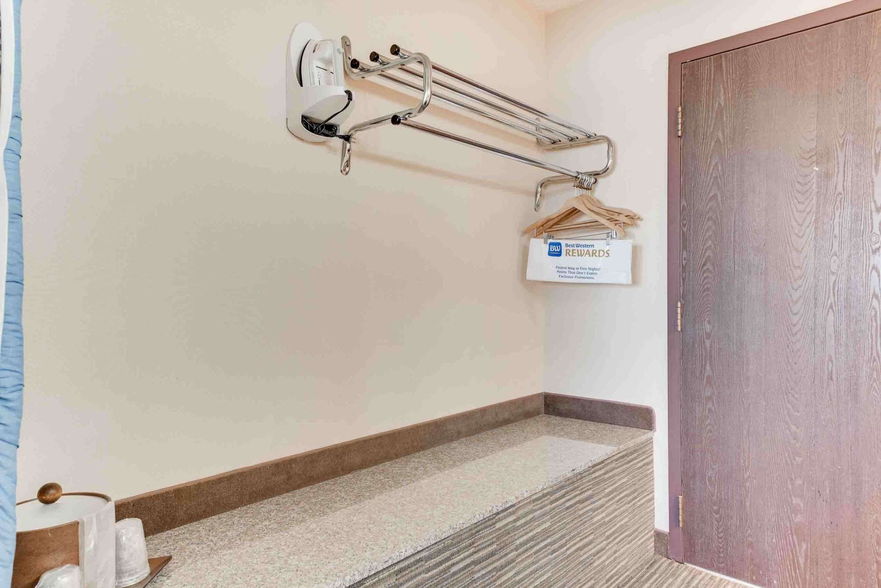 Ein Hotelkorridor mit Handlauf, einer Tür und einem kleinen Schild an der Wand.