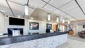 A reception area with a marble counter, a flat-screen TV, and framed pictures on the wall. - Best Western Movie Manor (Monte Vista)
