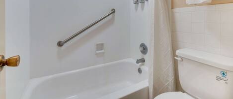 Un baño con bañera, ducha y retrete.