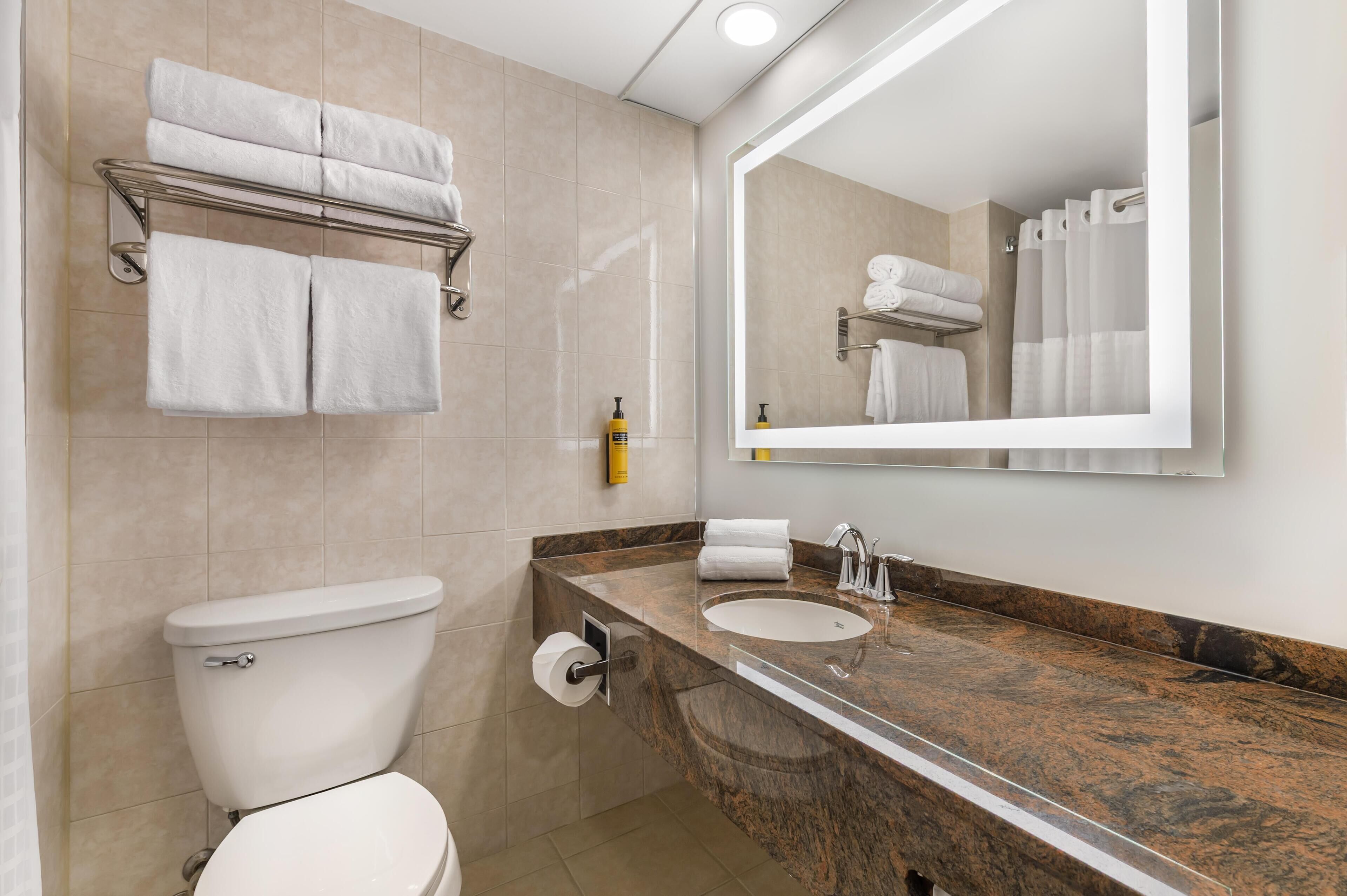 A bathroom with a toilet, sink, and towel rack.
