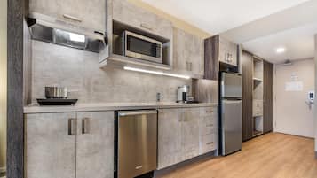 Una cocina moderna con electrodomésticos de acero inoxidable, lavavajillas y armarios de madera.