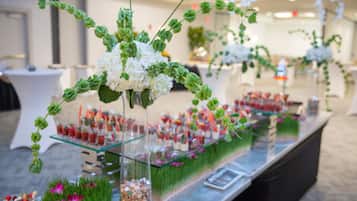 A buffet setup with glass display cases and floral arrangements.