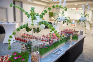 A buffet setup with glass display cases and floral arrangements.