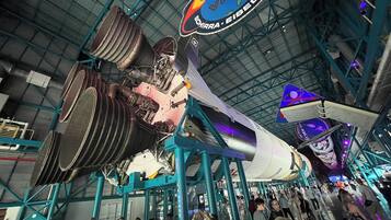 A space shuttle on display in a museum with visitors around it.