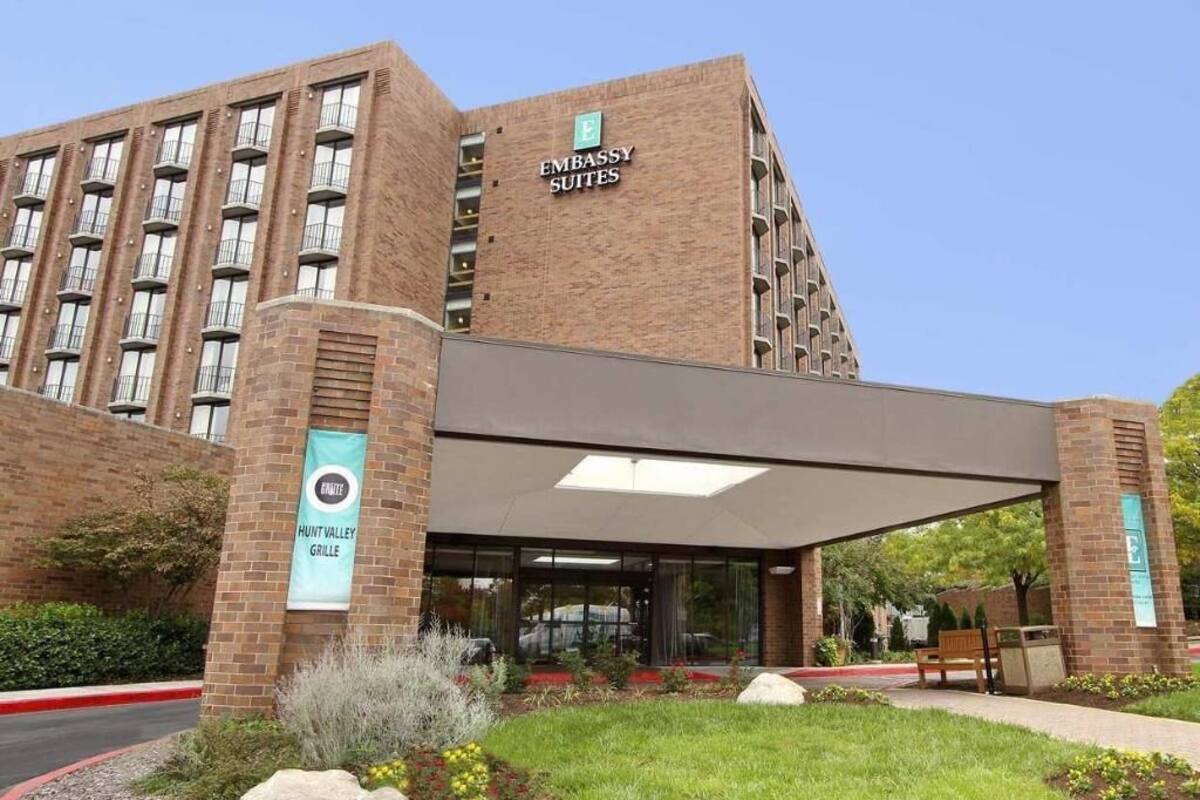 A brick building with a sign for 'Embassy Suites.'