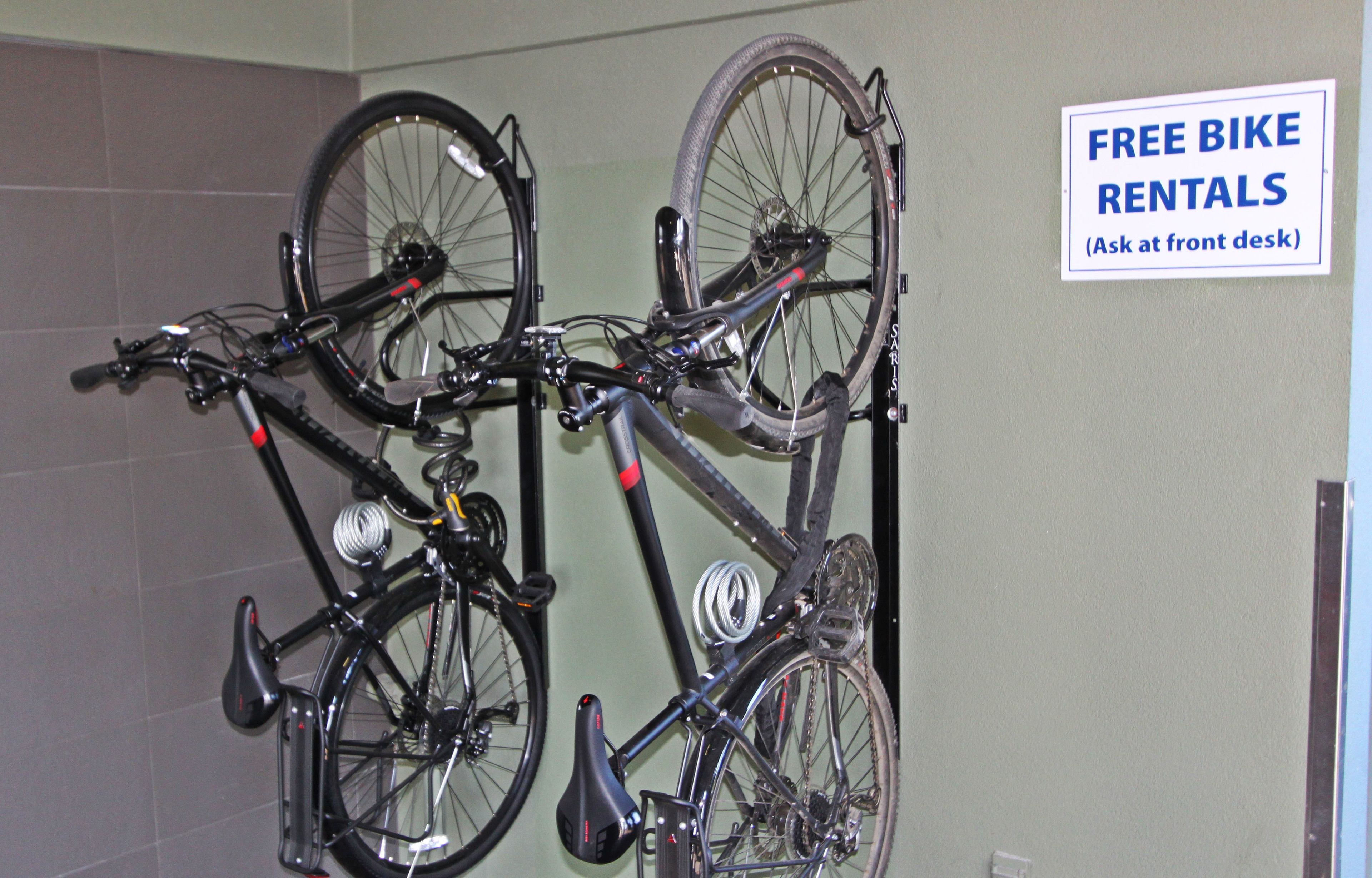 A wall-mounted bike rack with a sign indicating free bike rentals.