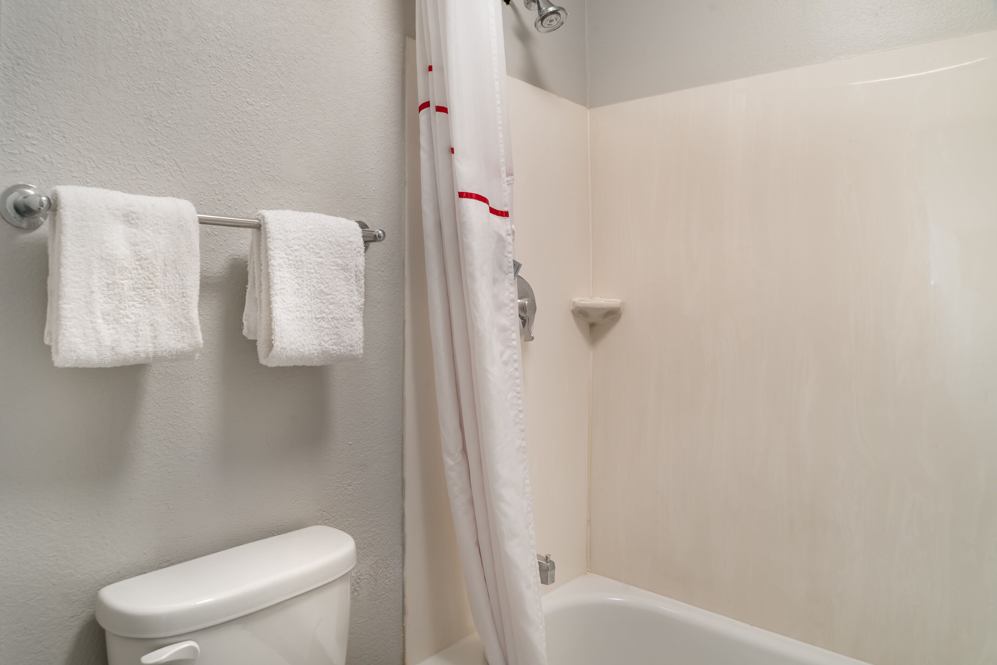 A bathroom with a toilet, a bathtub, and a shower curtain.