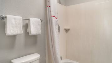 A bathroom with a toilet, a bathtub, and a shower curtain.