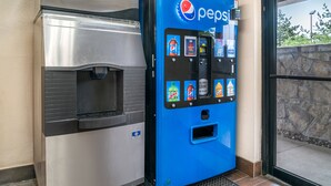 A Pepsi vending machine and a stainless steel beverage dispenser. - Red Roof Inn Detroit Metro Airport - Taylor (Taylor)