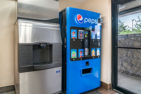 A Pepsi vending machine and a stainless steel beverage dispenser.