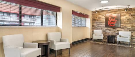 Un vestíbulo con asientos, una chimenea y una pared con el letrero de 'Red Roof Inn'.