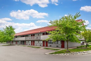 A two-story motel with a red roof, multiple windows, and a parking lot. - Red Roof Inn Detroit Metro Airport - Taylor (Taylor)