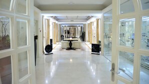 A spacious, well-lit hallway with a central table and chairs, flanked by glass doors and a polished floor. - Hotel Beatriz Toledo Auditorium & Spa (Toledo)
