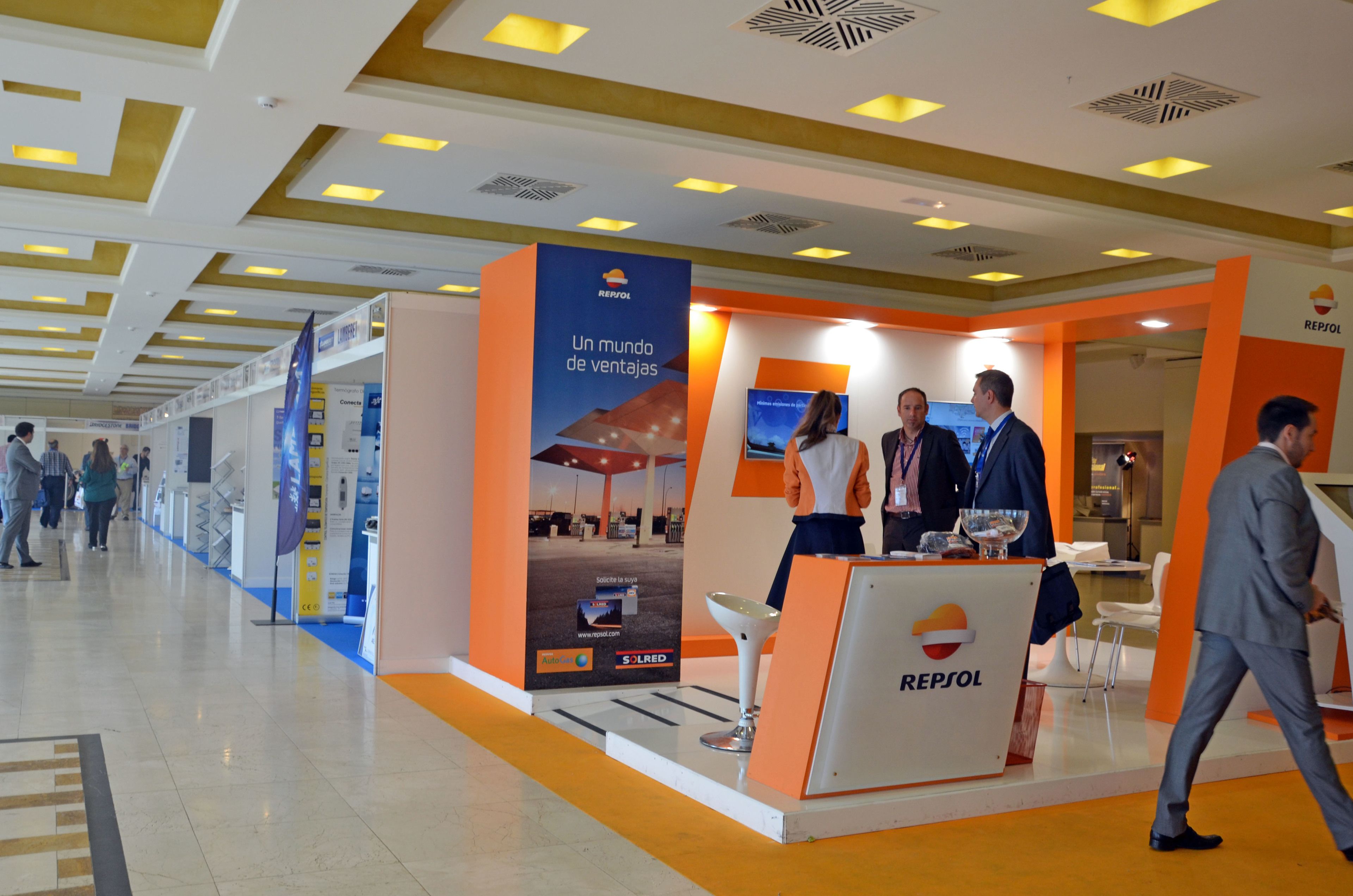 Puesto de exhibición de Repsol con un diseño moderno, que incluye una exhibición destacada y un área de descanso.