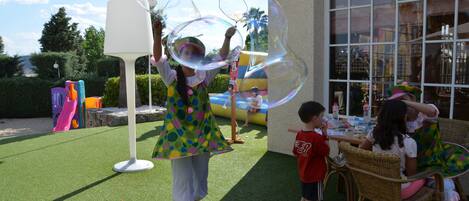 An outdoor area with artificial grass, a white lamp, and a play structure in the background.