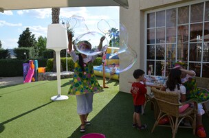 An outdoor area with artificial grass, a white lamp, and a play structure in the background.