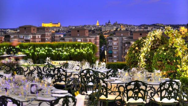 An outdoor dining area with tables set for a meal, surrounded by greenery and decorative lights. - Hotel Beatriz Toledo Auditorium & Spa (Toledo)