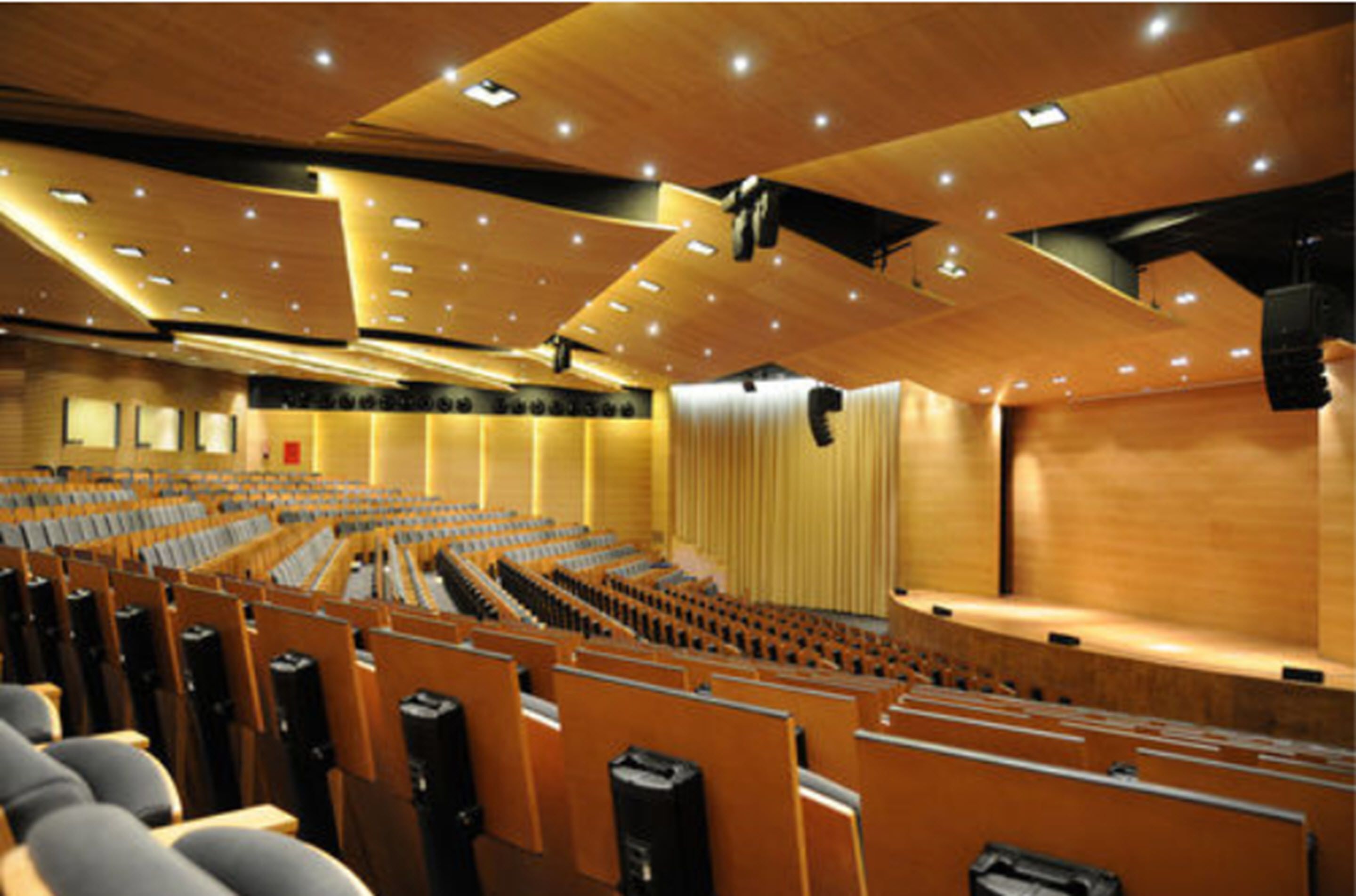 Un auditorio con asientos escalonados, un escenario y un interior de madera.
