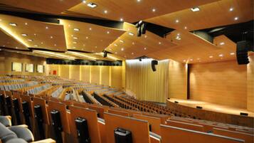 Un auditorio con asientos escalonados, un escenario y un interior de madera.