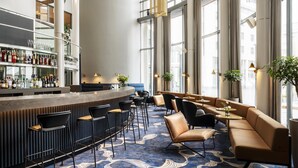 A bar area with a counter, stools, and a seating area with sofas and tables. - Radisson Blu Royal Hotel Helsinki (Helsinki)