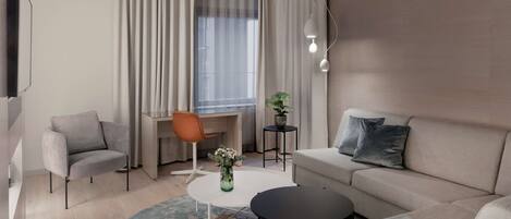 A modern living room with a sofa, two armchairs, a coffee table, a desk, and a potted plant.