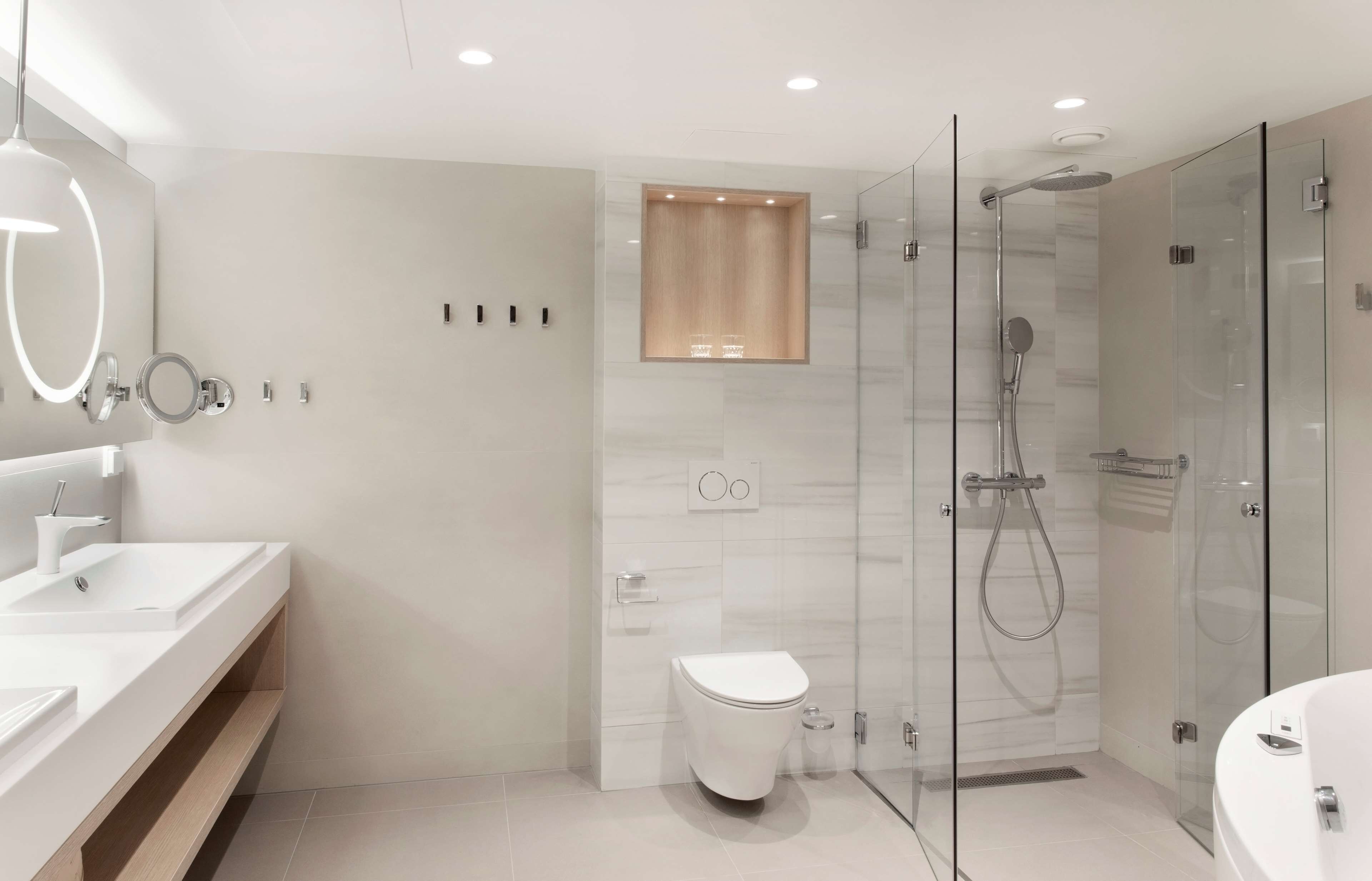 A modern bathroom with a glass-enclosed shower, a toilet, and a vanity with a mirror.