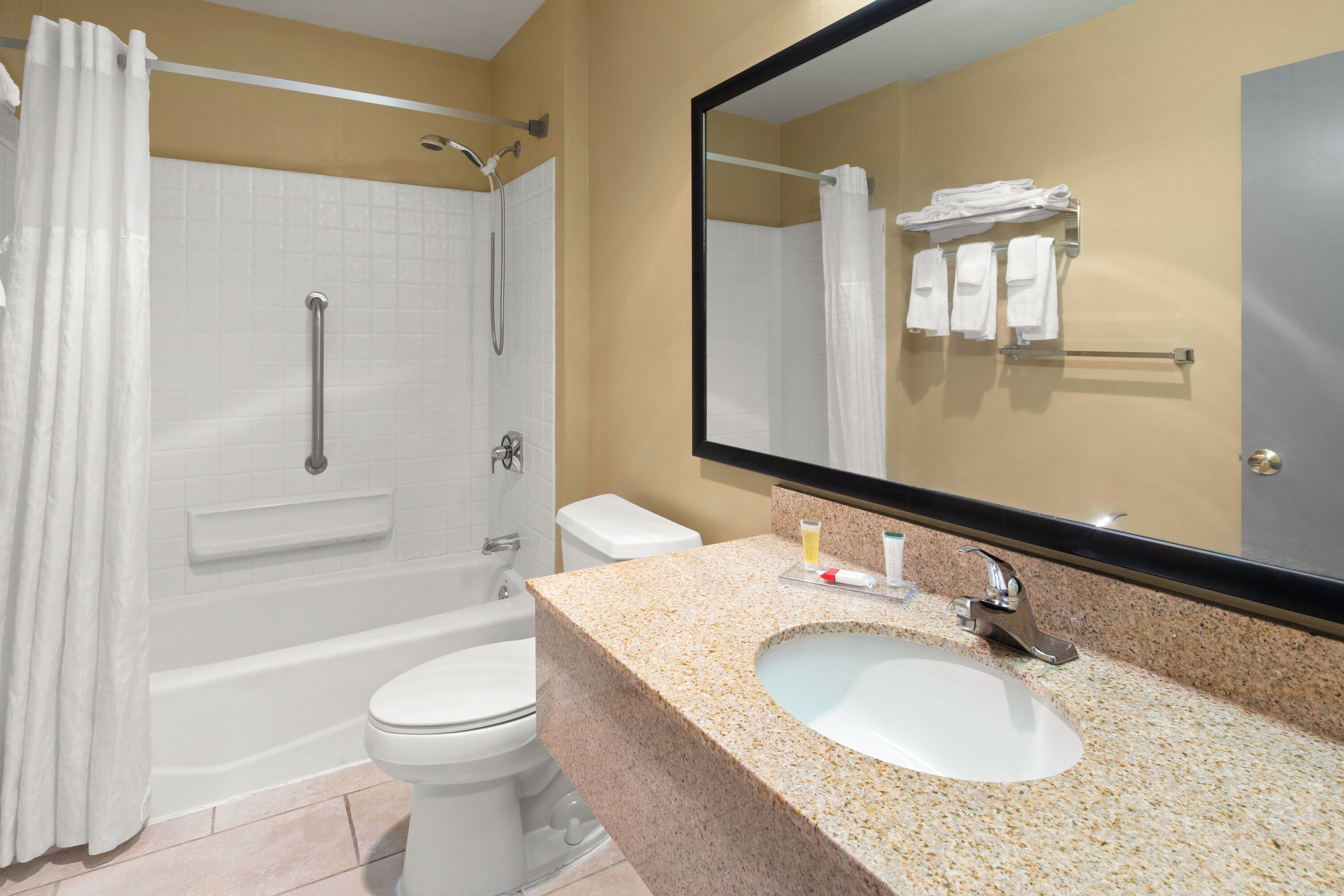 A bathroom with a bathtub, toilet, and sink.