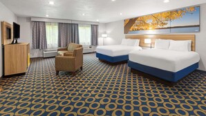 A hotel room with two beds, a TV, a desk, a chair, and a large window with curtains. - Days Inn by Wyndham Wauseon (Wauseon)