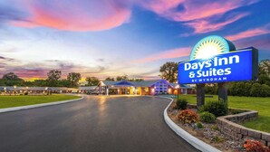 A Days Inn & Suites by Wyndham with a large illuminated sign, a well-maintained lawn, and a parking lot. - Days Inn by Wyndham Wauseon (Wauseon)