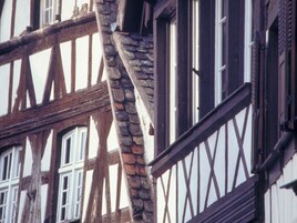 Un edificio de entramado de madera con vigas de madera a la vista y detalles de piedra.
