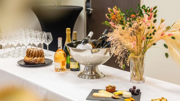 Een tafel met diverse gerechten, een fles wijn en een glas champagne.