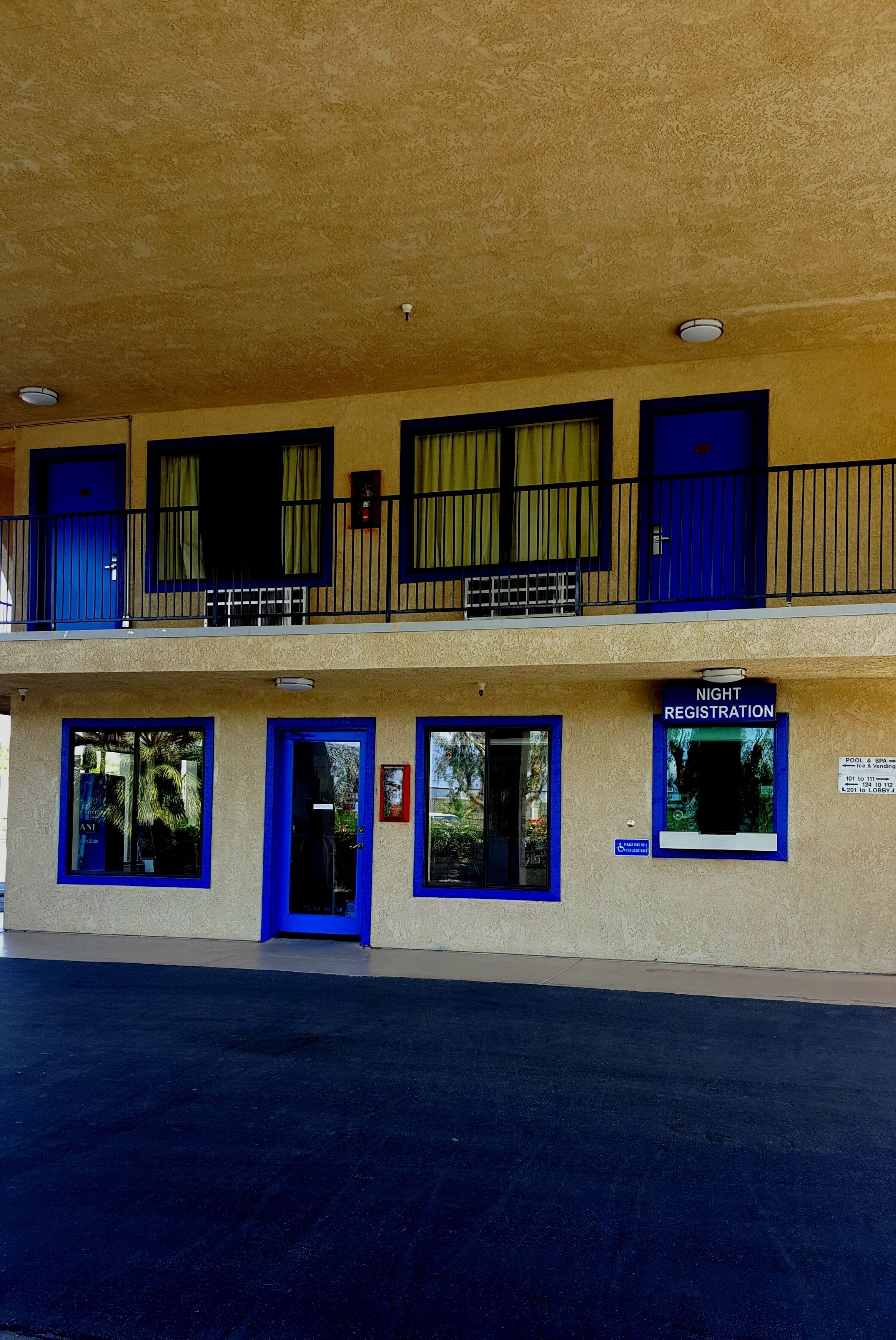 A building with a registration sign for night registration, multiple doors, and windows with curtains.