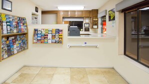 Una zona de recepción con mostrador, carteles informativos e impresora.