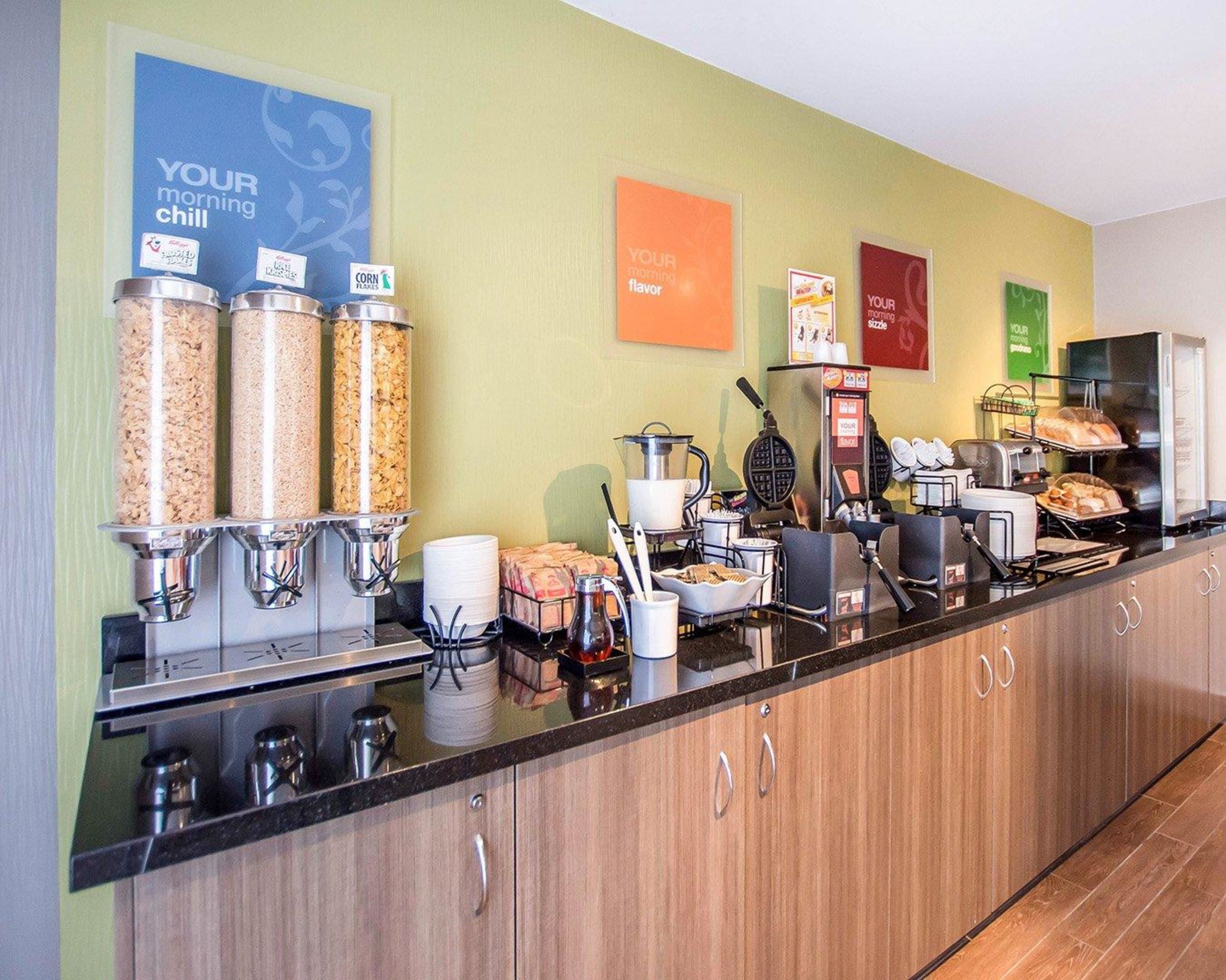 A breakfast bar with various food dispensers, a coffee machine, and a toaster.