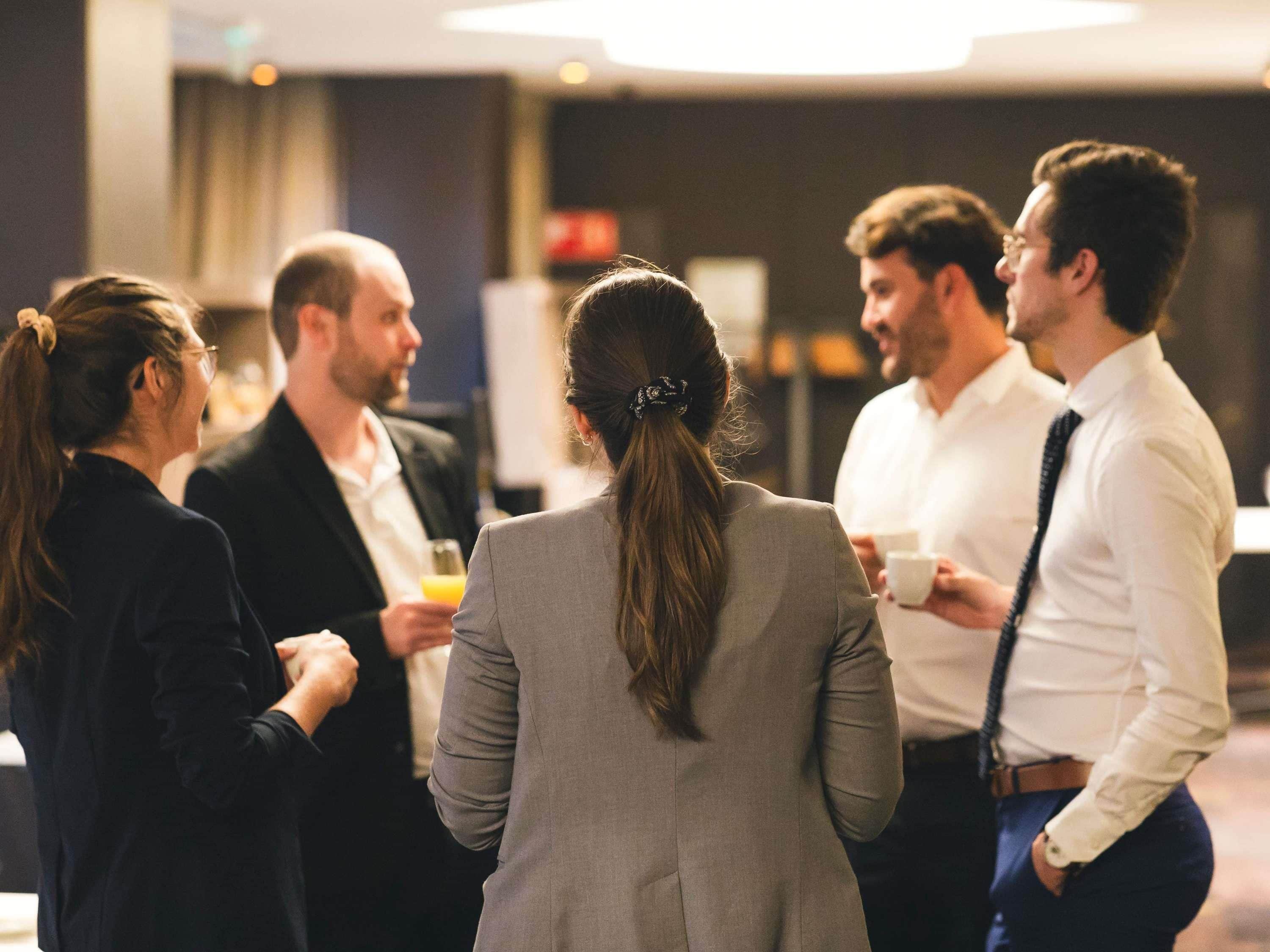 A group of people in a social setting, possibly a networking event or a casual gathering.