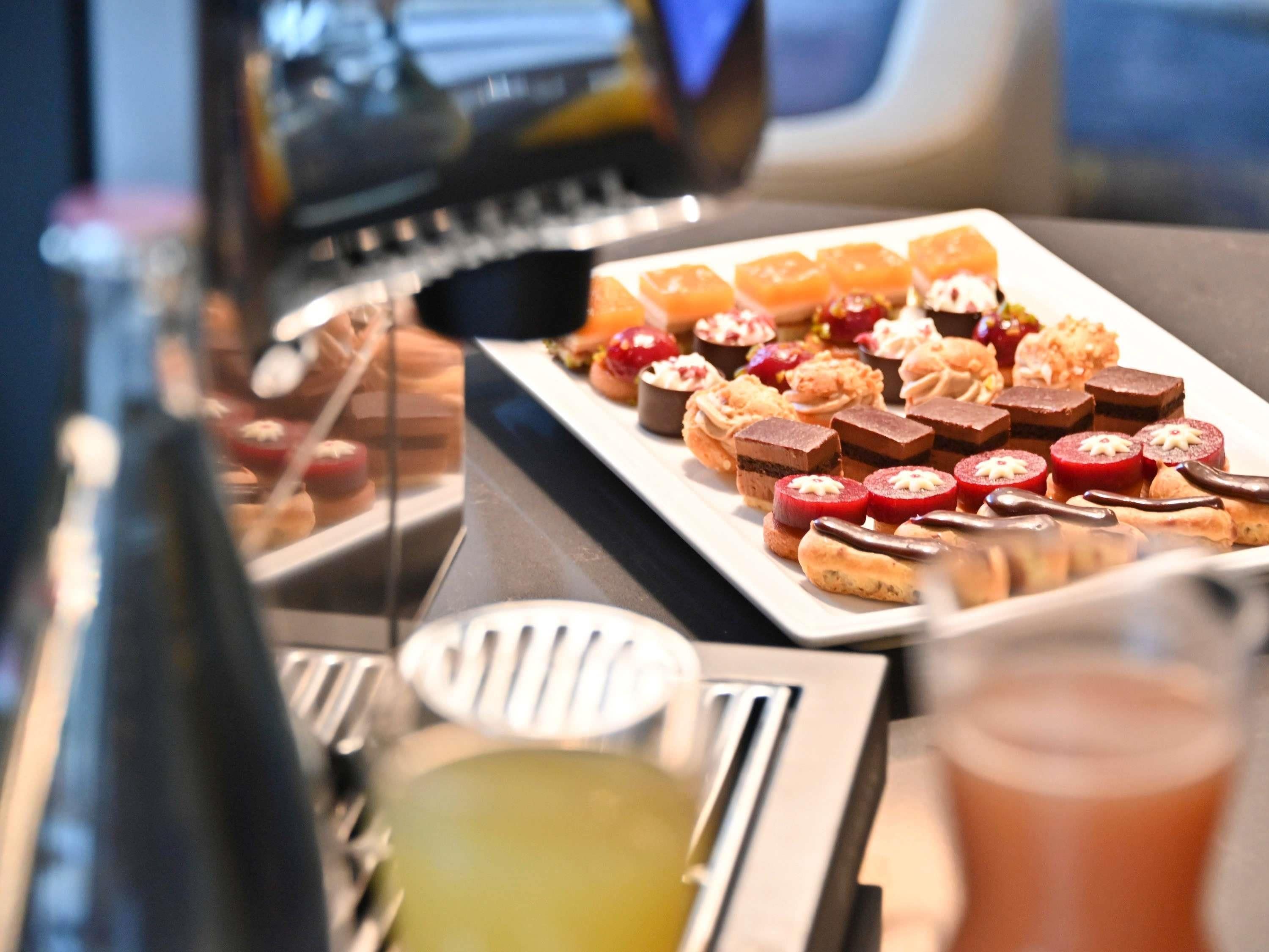 A buffet with various desserts and a bottle of wine.