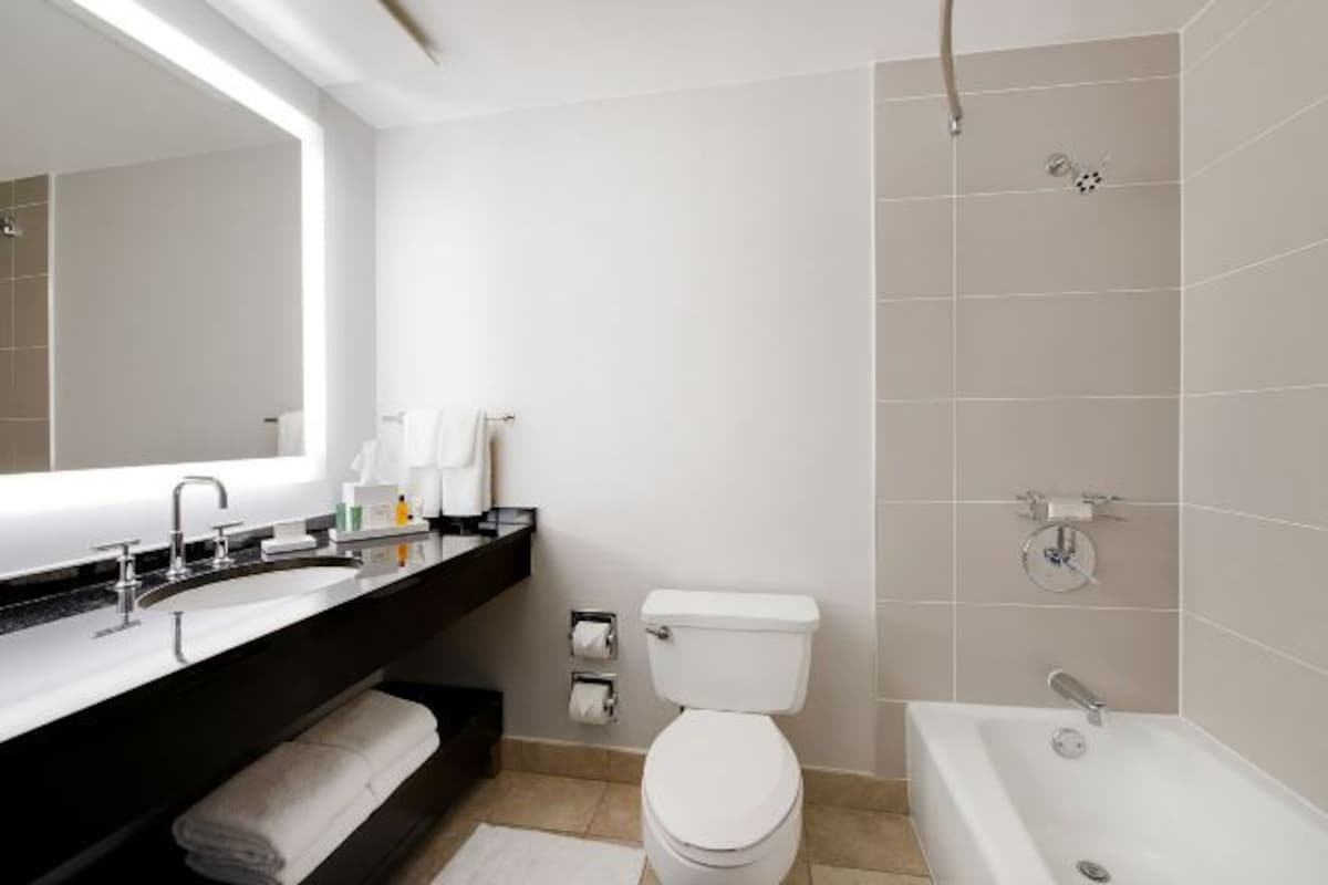 A modern bathroom with a sink, toilet, and bathtub.