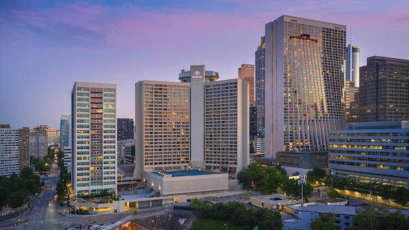 A cityscape with modern high-rise buildings, including a Hilton hotel.