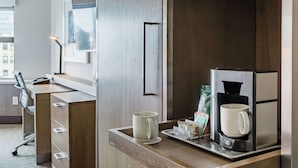 A modern hotel room with a wooden desk, a coffee machine, and a cup on the counter. - Coast Seattle Downtown Hotel by APA (Seattle)