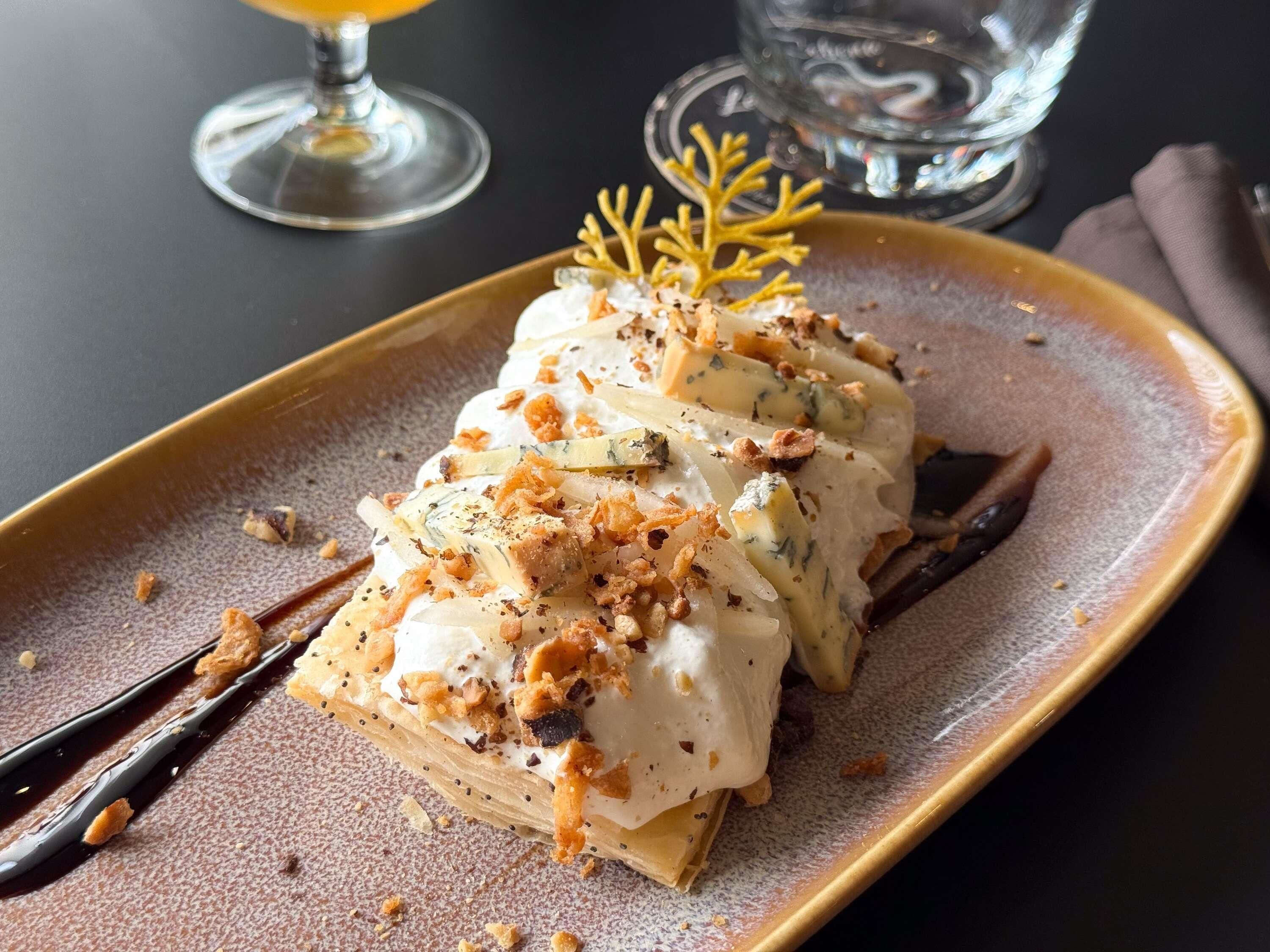 A dessert on a plate with a decorative leaf garnish.