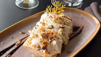 A dessert on a plate with a decorative leaf garnish.