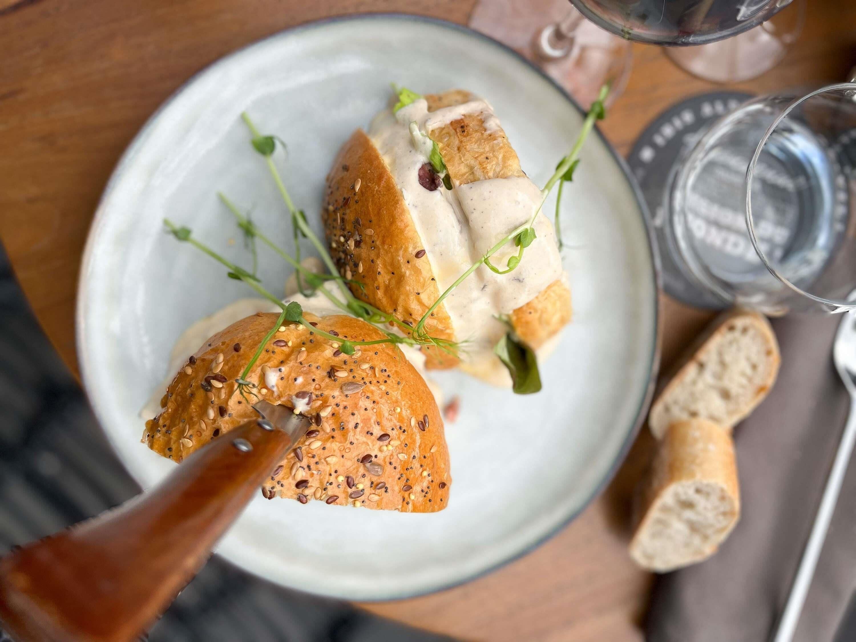 Une assiette contenant un plat, un verre d’eau et un verre de vin, le tout posé sur une table.