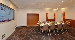 A conference room with a long table, chairs, and a projector screen displaying a welcome message. - Best Western Plus Delta Park Hotel (Mannheim)