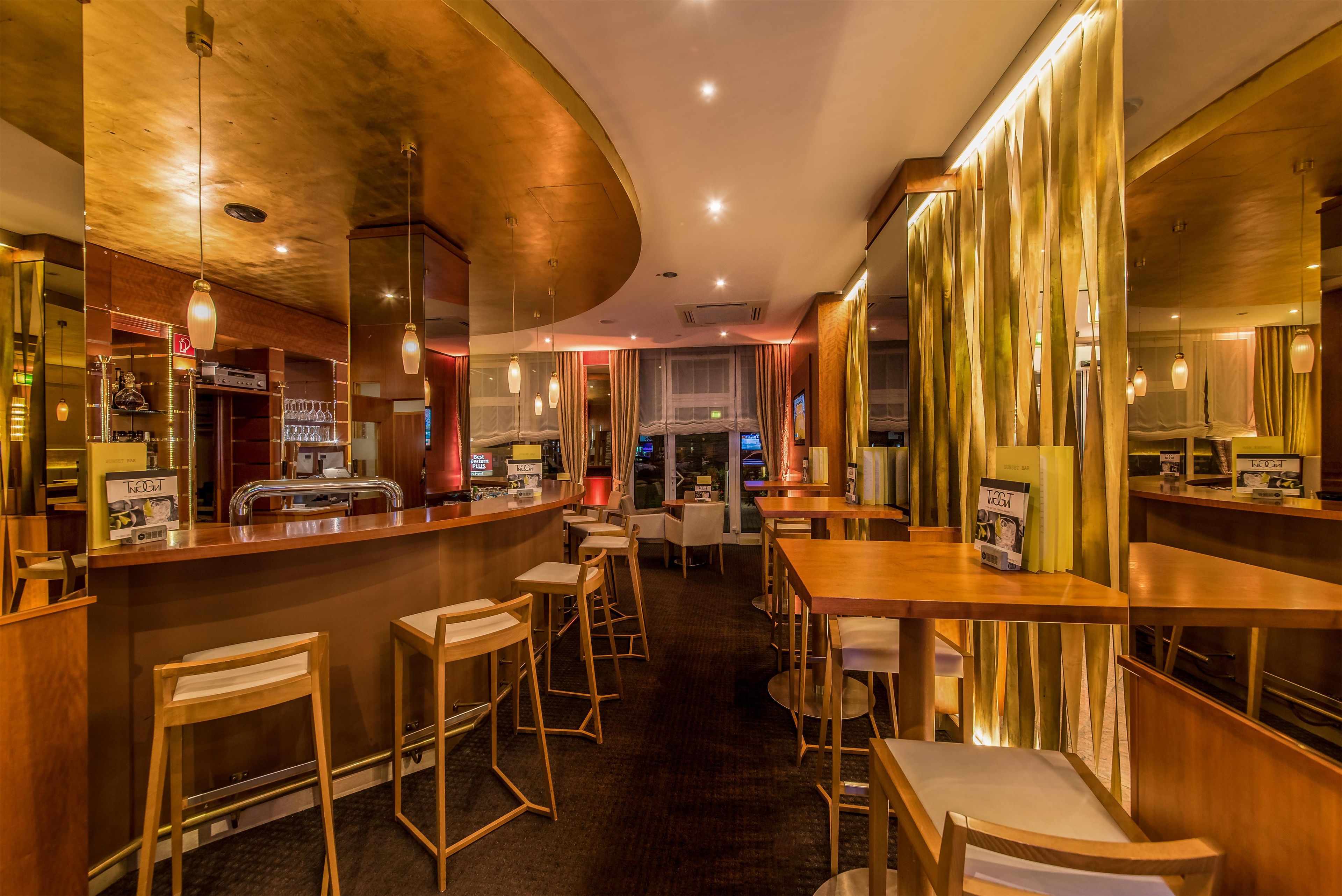 A bar area with wooden furniture, a curved ceiling, and pendant lighting.