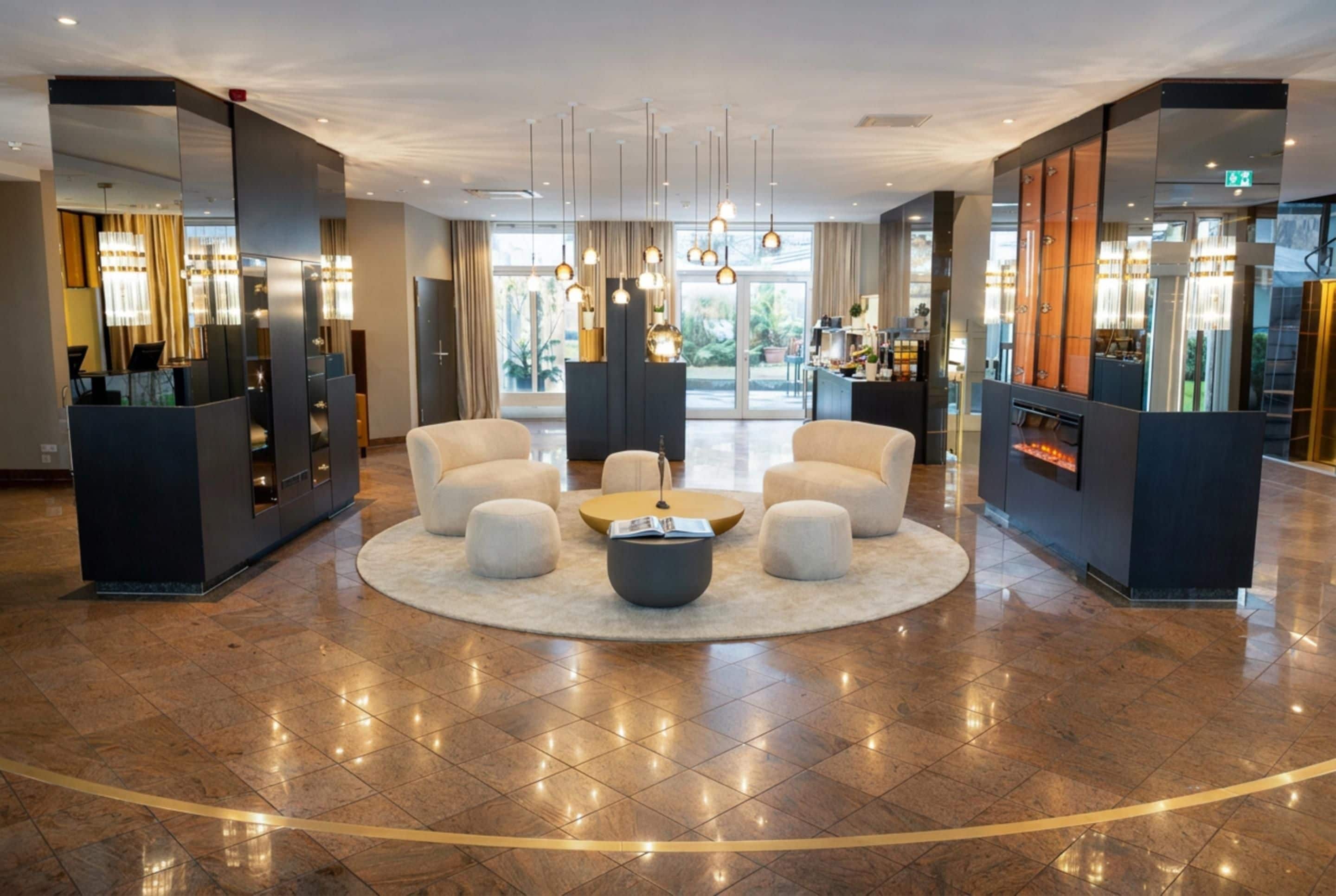 A hotel lobby with a central seating area, a reception desk, and a fireplace.