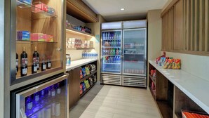 A narrow hallway with shelves stocked with snacks, beverages, and bottled water.