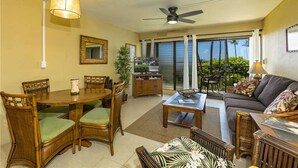 A spacious living area with a dining table, chairs, a sofa, and a ceiling fan. - Kihei Akahi - Maui Condo & Home (Kihei)
